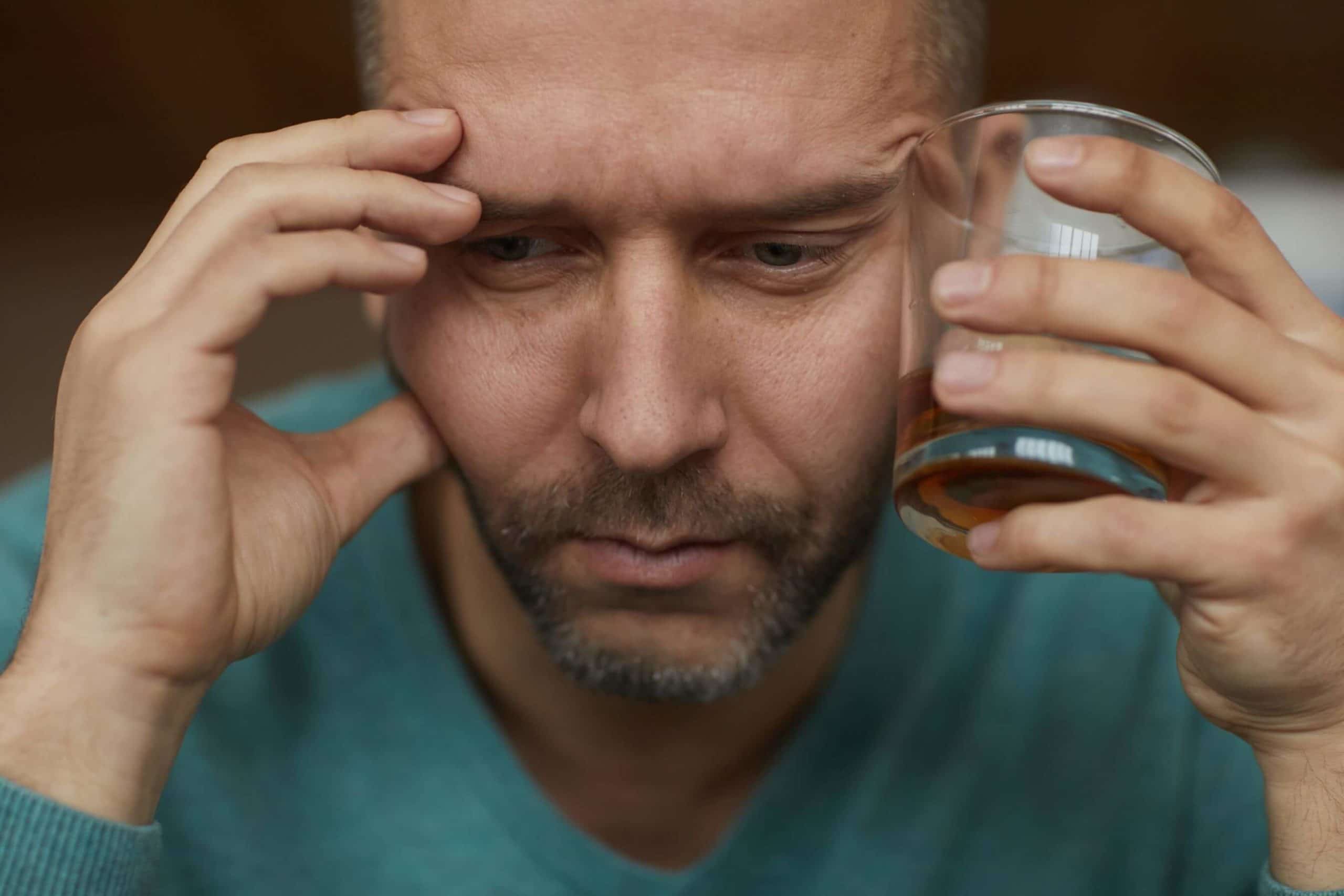 Man contemplating quitting drinking alcohol.